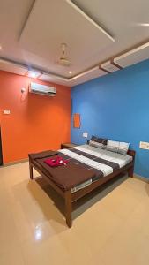 a bed in a room with a blue and red wall at Ramchandra home stay in Malvan