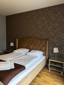 1 dormitorio con 1 cama grande y pared marrón en Hotel Pod Strzechą, en Kielce