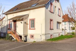 an old white house with red windows on a street at Charmant appart près Europa-Park Rulantica 30 min in Erstein