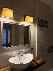 a bathroom with a sink and a mirror at Hotel Pod Strzechą in Kielce +30 photos