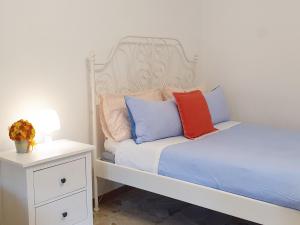 a bed with two pillows on it next to a night stand at Fiori e Frutti Locazione Turistica in Almese