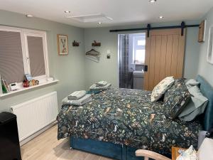 a bedroom with a bed with a comforter on it at Woodland View in East Harling