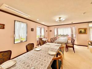 a dining room with long tables and chairs at 風薫る宿 伊豆星の舞 in Ito