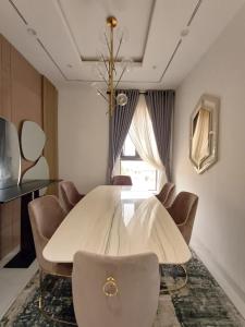 Un comedor con una mesa y sillas blancas. en Horyn Homes, en Lekki