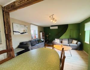 a living room with a table and a couch at Le gîte du faubourg in Sautour