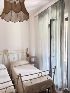 a bedroom with two beds and a chandelier at La Rosa di Tempalta in Roccadaspide