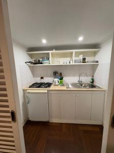 Una pequeña cocina con fregadero y estufa. en La dolce Silla - Appartamenti al Vaticano,Via Silla 91, en Roma