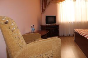 a living room with a chair and a table with a television at Passage Hotel in Berehove