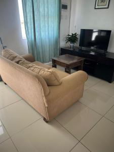 a brown couch in a living room with a television at Dwellers Double in Grassy Park +2 photos