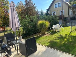 a patio with an umbrella and a table and chairs at B2 Apartman in Balatonszemes