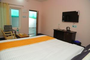 une chambre d'hôtel avec un lit et une télévision à écran plat dans l'établissement Seawave Beach Resort, à Bahūr