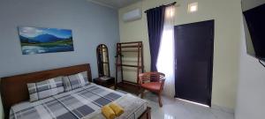 Un dormitorio con una cama y una silla y un televisor. en Mentari Homestay, en Sentool