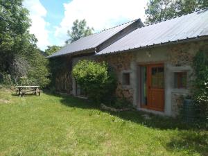 a stone house with a picnic table in the yard at Forest House by Lake Pannecière in Chaumard