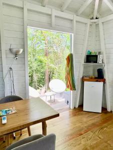 un soggiorno con un tavolo e una grande finestra di Bungalow vue mer - Deshaies a Deshaies