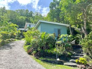 a house with a garden and a gravel driveway at Bungalow vue mer - Deshaies in Deshaies