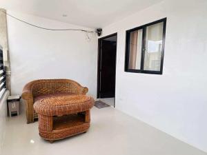 a wicker chair and a stool in a room at JMary Stayhouse in Nopol