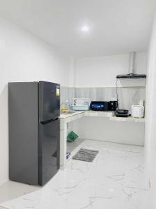 a kitchen with a stainless steel refrigerator and a counter at JMary Stayhouse in Nopol
