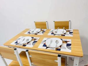 a wooden table with plates and utensils on it at JMary Stayhouse in Nopol
