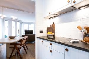 クノック・ヘイストにあるA Bien Venueのキッチン(白いキャビネット、カウンタートップ付きテーブル付) +25枚の写真