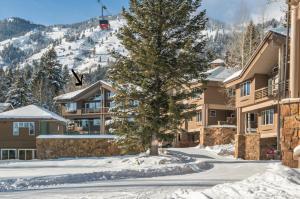 テトン・ビレッジにあるRMR: Tram Tower 5 Condo in Teton Villageのロッジの前の雪の中の木