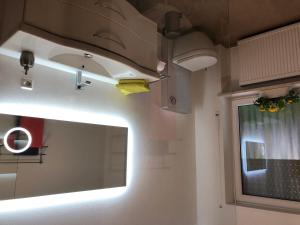 a bathroom with a mirror and a towel hanging from the ceiling at Ferienbungalow Anne in Wadern +18 photos
