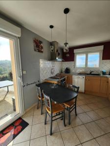 a kitchen with a black table and chairs and a table at maison in Le Thillot