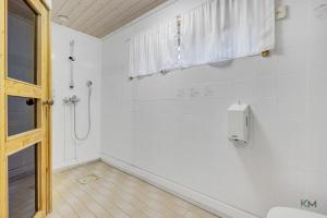 a white bathroom with a shower and a window at Villa Aurora - Valkea Homes in Pelkosenniemi +29 photos