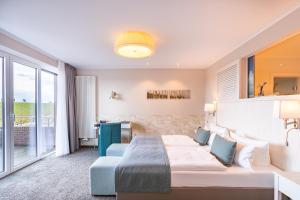 a hotel room with a bed and a large window at Hotel Regina Maris in Norddeich +59 photos