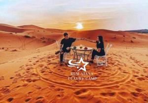 a couple sitting at a table in the desert at WADI RUM ATANO lUXURY CAMP in Wadi Rum
