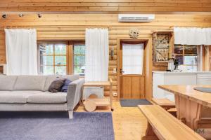 a living room with a couch and a table at Villa Aurora - Valkea Homes in Pelkosenniemi