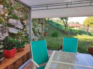 a table and chairs on a patio with a stone wall at El jardín de Max, apartamento céntrico con jardín privado y parking in Comillas +11 photos
