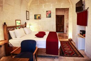 una camera da letto con un letto con cuscini rossi sopra di Peruna Cave a Göreme