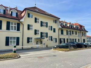 a large building with cars parked in a parking lot at Ana Marija Apartment - Vila Golf in Rogaška Slatina
