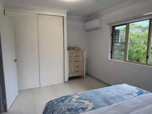ein weißes Schlafzimmer mit einem Bett und einem Fenster in der Unterkunft Coral Oasis - Cairns - Holloways Beach in Holloways Beach + 11 Fotos