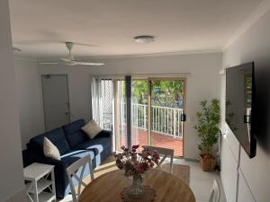 un salon avec un canapé bleu et une table dans l'établissement Coral Oasis - Cairns - Holloways Beach, à Holloways Beach