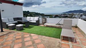 a patio with a couch and a table on a roof at Modern apartment in Patong Center in Ban Nong Chaeng