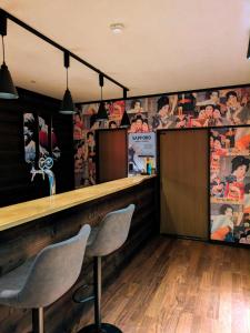 a bar with two chairs in a room with posters at The Nook Hakuba in Hakuba