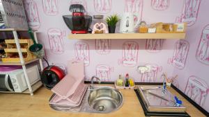 a pink kitchen with a sink and a mixer at Lemon & Green GuestHouse in Granada