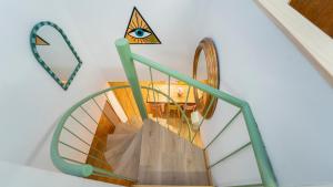 a spiral staircase with an eye on the wall at Lemon & Green GuestHouse in Granada