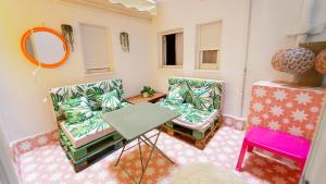 a room with two chairs and a table and a mirror at Lemon & Green GuestHouse in Granada