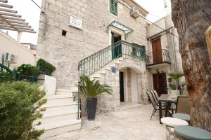 a stone house with a balcony and a table at Iron Gates Apartments in Split