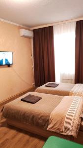 2 camas en una habitación de hotel con TV en la pared en Василя Стуса 10 City Rooms, en Bila Tserkva 20 fotos más