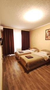 Una habitación de hotel con dos camas y una ventana. en Василя Стуса 10 City Rooms, en Bila Tserkva