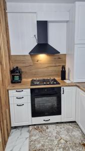 a kitchen with white cabinets and a stove top oven at Apartament EVA in Suceava