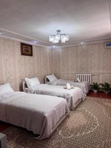 a room with three beds and a chandelier at Cholpon Guest House in Bishkek