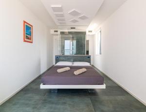 a bed in a white room with two pillows on it at Sea Emotions Suite in Peschici