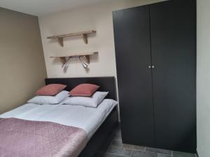 a bedroom with two beds and a black cabinet at Mooi zo 2 in De Koog
