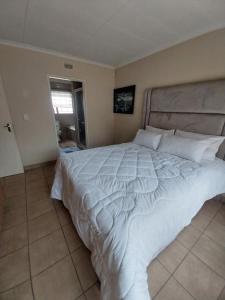 a bedroom with a large white bed in a room at Lubsman Apartments in Centurion