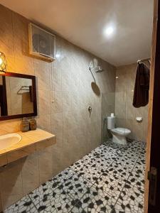 a bathroom with a shower and a toilet and a sink at Willy Homestay in Uluwatu