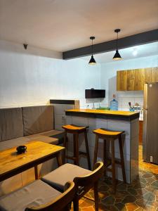a kitchen with wooden tables and chairs and a refrigerator at Willy Homestay in Uluwatu